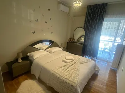 a bedroom with a bed with birds on the wall at Alex Apartment in Athens