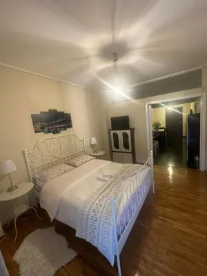 a bedroom with a white bed with a white bed frame at Alex Apartment in Athens