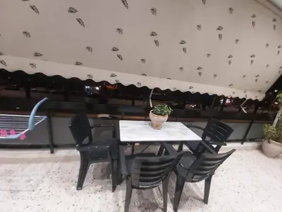 a table with black chairs and a potted plant on it at Alex Apartment in Athens