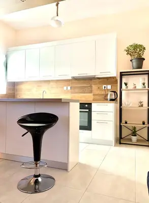 a black stool in a kitchen with white cabinets at Athens nice apartment in Athens