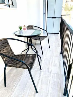 a glass table and chairs on a balcony at Athens nice apartment in Athens