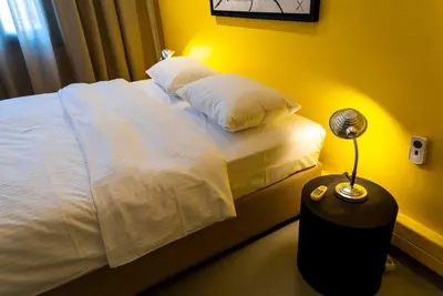 a bedroom with a bed with a lamp on a table at Artistic Spacious Studio Apartment next to metro Monastiraki in Athens