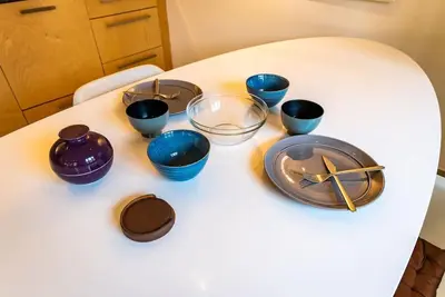 a table with blue bowls and a clock on it at Artistic Spacious Studio Apartment next to metro Monastiraki in Athens
