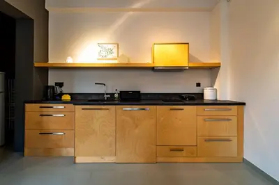 a kitchen with wooden cabinets and a sink at Artistic Spacious Studio Apartment next to metro Monastiraki in Athens