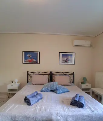 a bedroom with a bed with blue towels on it at Cozy studio Maria in Paleo Faliro in Athens