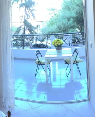 a white table and two chairs on a balcony at Cozy studio Maria in Paleo Faliro in Athens