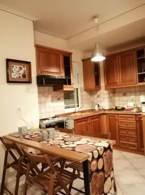 a kitchen with a wooden table with chairs in it at Cozy studio Maria in Paleo Faliro in Athens