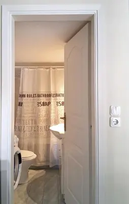 a bathroom with a toilet and a shower curtain at Cozy studio Maria in Paleo Faliro in Athens