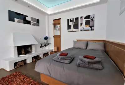 a bedroom with a bed and a fireplace at Stunning view private terrace studio @Panormou Metro. in Athens