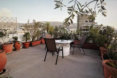 a balcony with a table and chairs and potted plants at Stunning view private terrace studio @Panormou Metro. in Athens