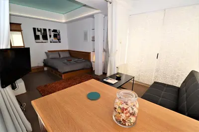 a living room with a table and a couch at Stunning view private terrace studio @Panormou Metro. in Athens