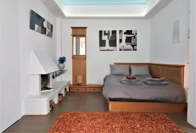 a bedroom with a bed and a fireplace at Stunning view private terrace studio @Panormou Metro. in Athens