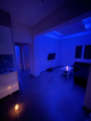 a blue room with a couch and a tv and a table at The Sandbox in Athens