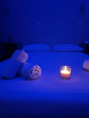 a blue room with a bed with a candle on it at The Sandbox in Athens