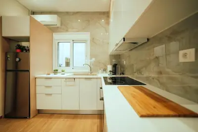 a kitchen with white cabinets and a black refrigerator at The Sandbox in Athens