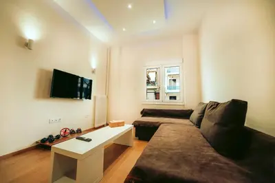 a living room with a couch and a flat screen tv at The Sandbox in Athens