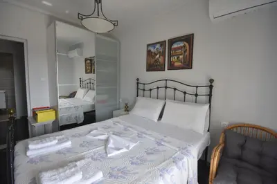 a bedroom with a bed and a chair and a mirror at VillaVita Modern 3BR,Garden & BBQ, Walk to Beach in Kalívia Thorikoú