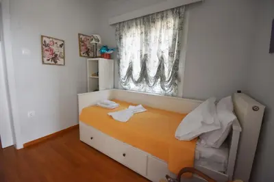 a small bedroom with a bed and a window at VillaVita Modern 3BR,Garden & BBQ, Walk to Beach in Kalívia Thorikoú