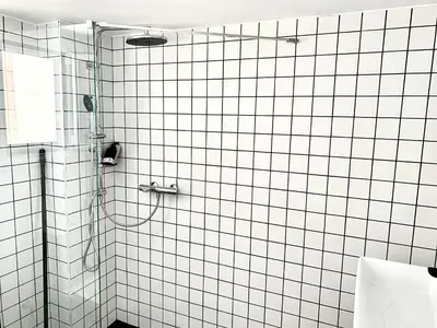a bathroom with a shower with white tile walls at Fyllis16-Sunny central apartment next to Metro sta in Athens