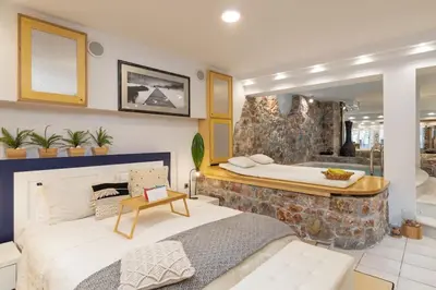 a bedroom with a large bed and a tub at Efi's DreamSpace in Athens