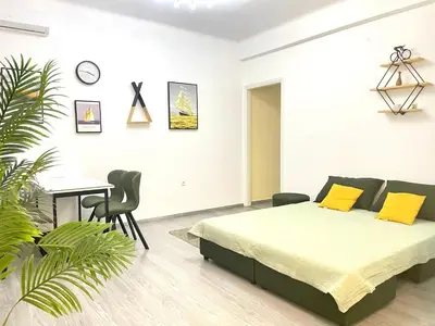 a bedroom with a bed and a table and a desk at Uoohome7 garden green and navy in Athens