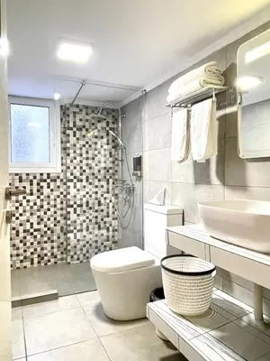a bathroom with a toilet and a sink and a shower at Uoohome7 garden green and navy in Athens