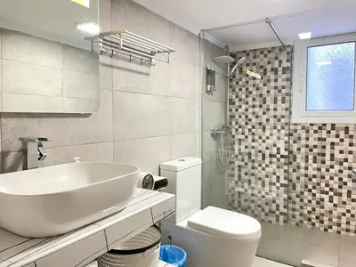 a white bathroom with a sink and a toilet at Uoohome7 garden green and navy in Athens