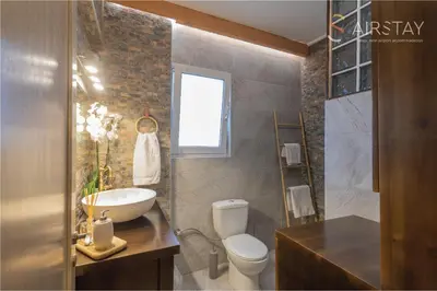 a bathroom with a toilet and a sink and a mirror at Kalista apartment Airport by Airstay in Spáta