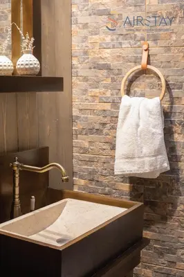 a bathroom with a sink and a towel on a wall at Kalista apartment Airport by Airstay in Spáta
