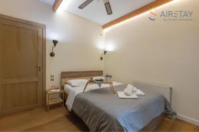a bedroom with a bed with a table on it at Kalista apartment Airport by Airstay in Spáta
