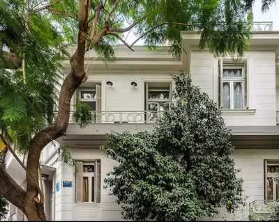 a white house with a tree in front of it at Oasis Architect's Dream Neoclassical House next to Acropolis in Athens