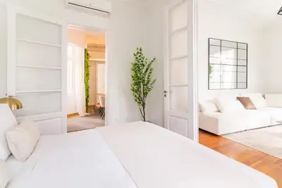 a white bedroom with a white bed and a white couch at Oasis Architect's Dream Neoclassical House next to Acropolis in Athens