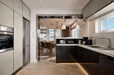 a kitchen with black and white cabinets and a table at Elaia Luxury Selections Opal in Athens