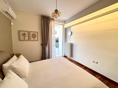 a bedroom with a bed and a window at Elaia Luxury Selections Opal in Athens