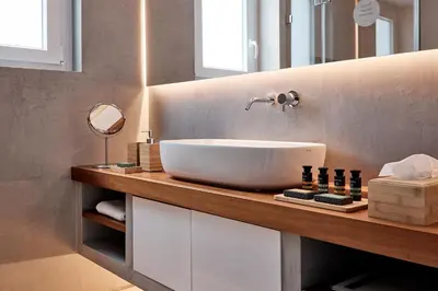 a bathroom with a white sink on a wooden counter at Elaia Luxury Selections Opal in Athens