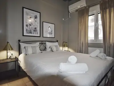 a bedroom with a large white bed with towels on it at Petite Apartment in Athens