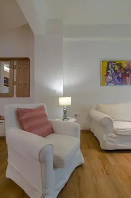 a white living room with a couch and a lamp at Nice 1BD apartment close to metro station Ampelokipoi in Athens