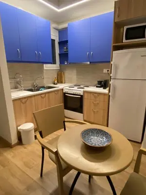 a kitchen with blue cabinets and a table with a bowl on it at Nice 1BD apartment close to metro station Ampelokipoi in Athens