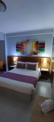 a bedroom with a large bed with paintings on the wall at Poseidonio in Piraeus