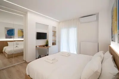 a white bedroom with a large bed and a desk at Kolonaki Upscale 4 bedroom Luxury Apartment in Athens