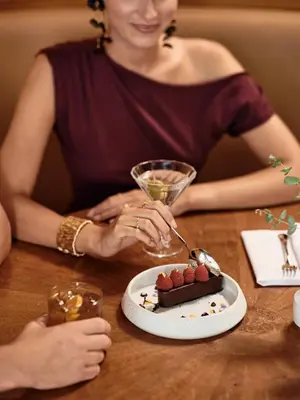 a woman sitting at a table with a plate of food at Titania Hotel in Athens