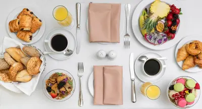 a white table topped with plates of food and breakfast foods at Titania Hotel in Athens