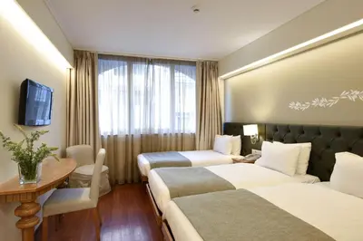 a hotel room with two beds and a table at Titania Hotel in Athens