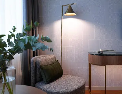 a room with a chair and a lamp and a table at Titania Hotel in Athens