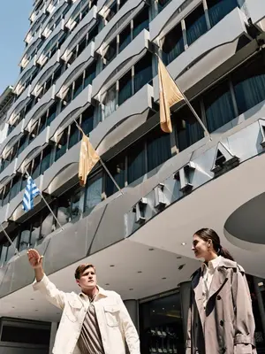 two men standing in front of a cruise ship at Titania Hotel in Athens