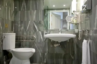 a bathroom with a toilet and a sink and a mirror at Hera Hotel in Athens