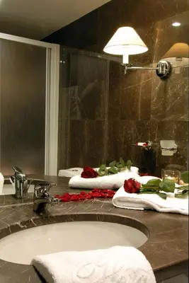 a bathroom with two sinks with towels and a mirror at Hera Hotel in Athens