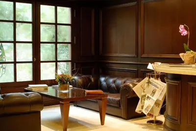 a living room with a leather couch and a table at Hera Hotel in Athens