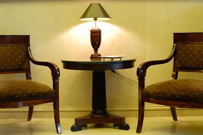 a table with a lamp on it next to two chairs at Hera Hotel in Athens