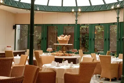a restaurant with tables and chairs with a cake on top at Hera Hotel in Athens